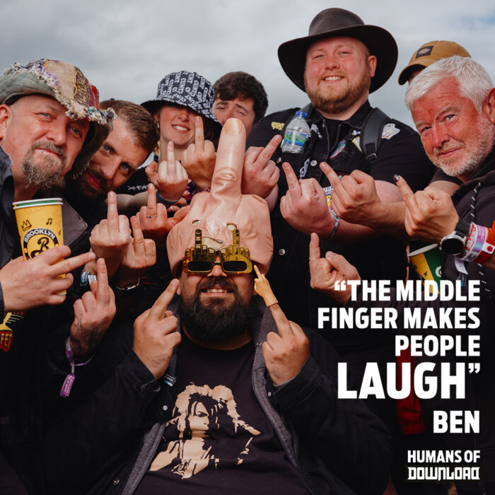 Download fans around a fan wearing middle finger hat and glasses striking a pose with caption text: 'The middle finger makes people laugh.' - Ben - Humans of Download