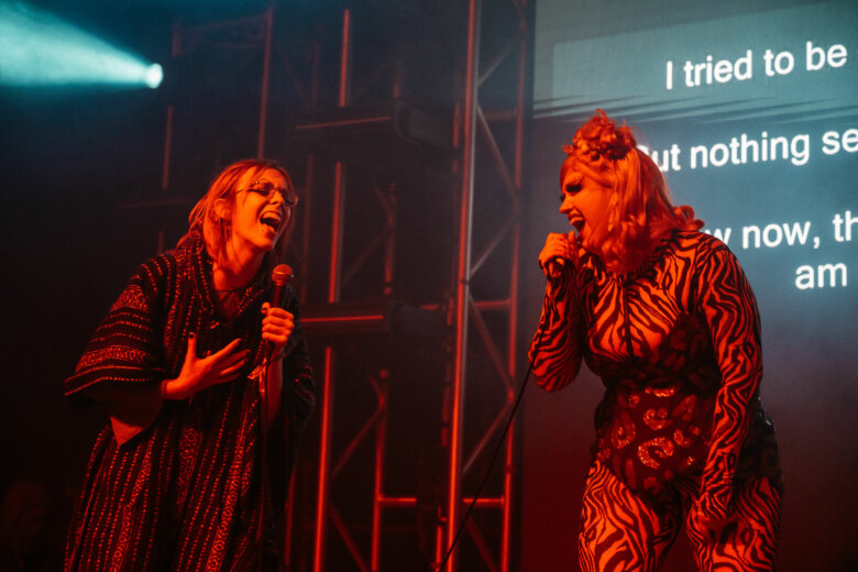 Drag Queens singing karaoke on stage