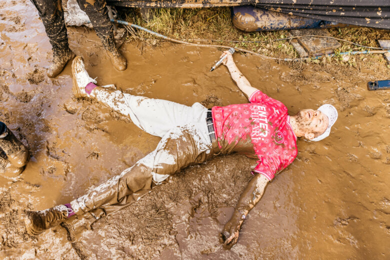 Rou from Enter Shikari laying in mud