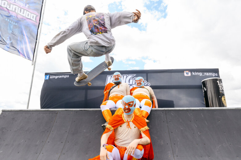 Pro skateboarders jumping over mariachi wrestlers