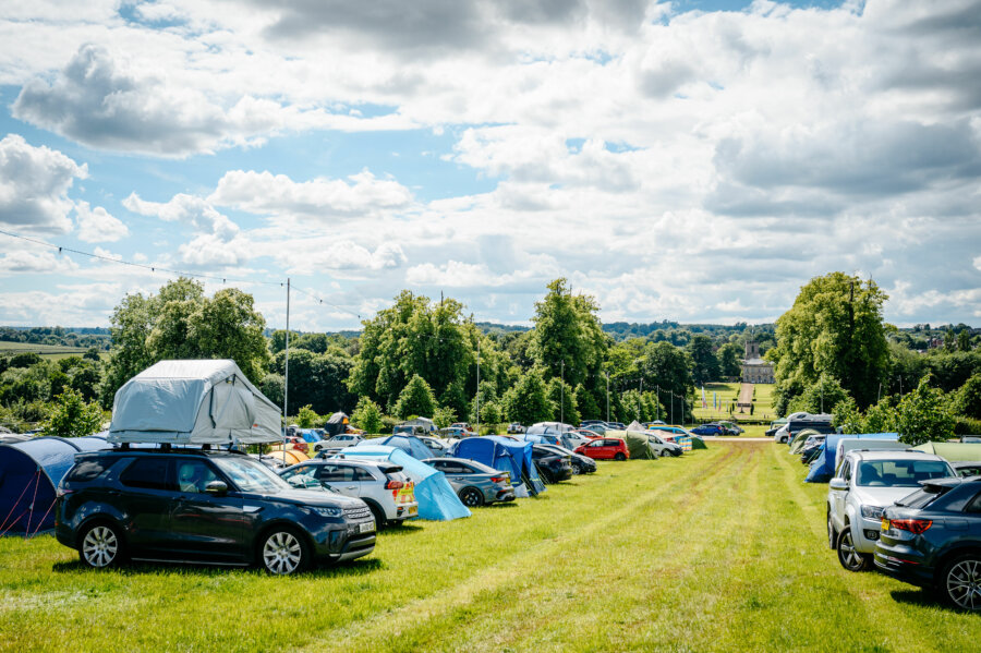 Photograph of multiple rows of cars with adjacent tents