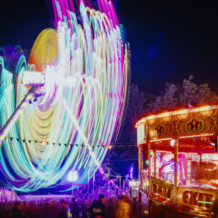 The ferris wheel in District X at night and illuminated in colour.
