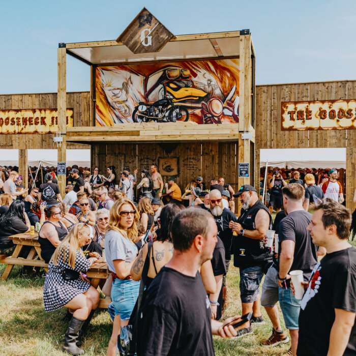 Download fans walking across the shot with the Gooseneck Inn in the background.