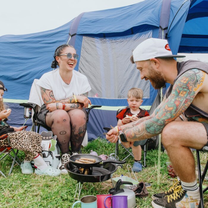 Download fans cooking food outside their tent.
